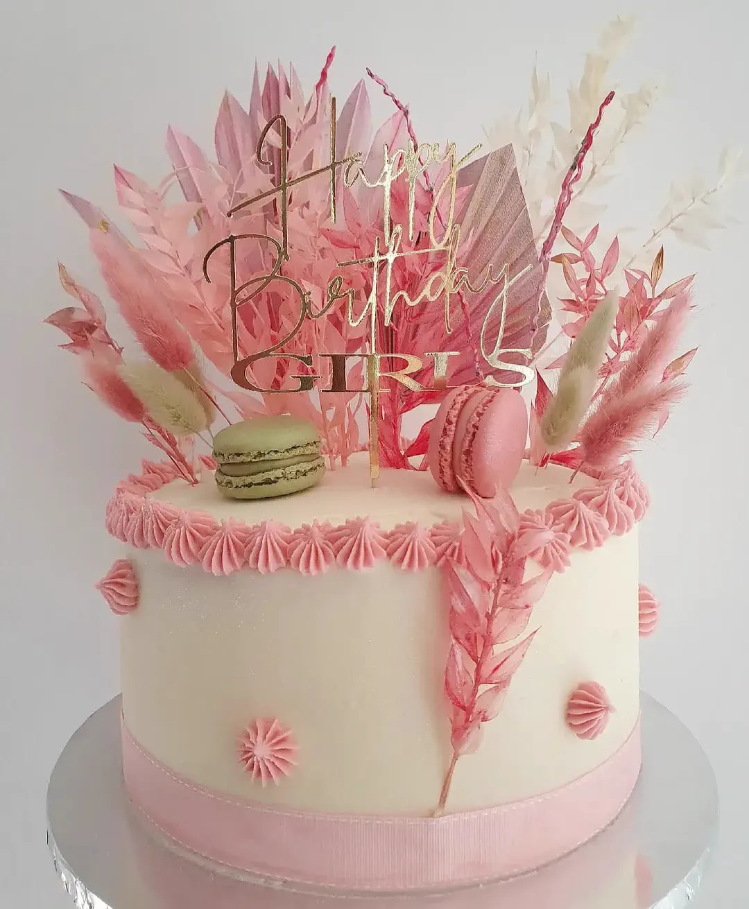 Pink birthday cake with macarons and a gold topper by Cupcake Tizzle