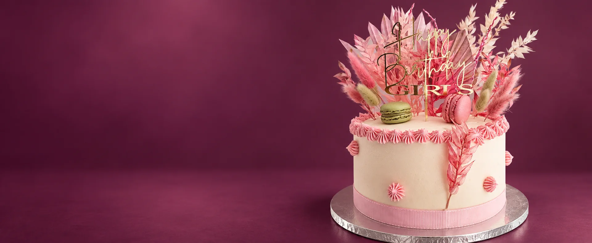 Pink birthday cake with macarons and a gold topper by Cupcake Tizzle